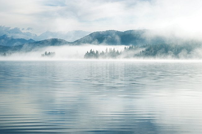 mists rising over mountain lake