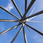 looking up at the sky through the frame of a tipi
