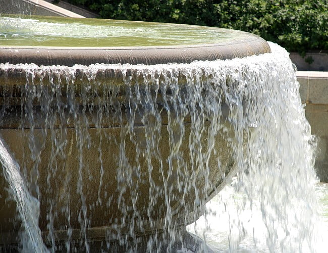 water overflowing a fountain basin